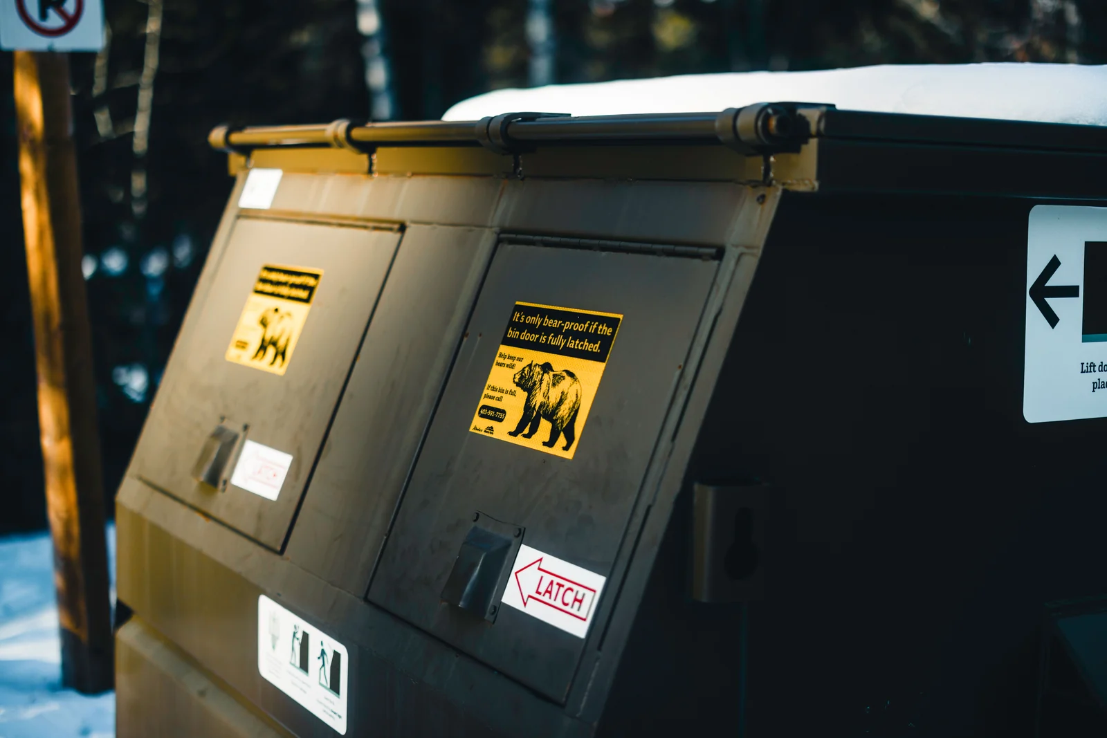 A latched bin in snow with warning stickers
