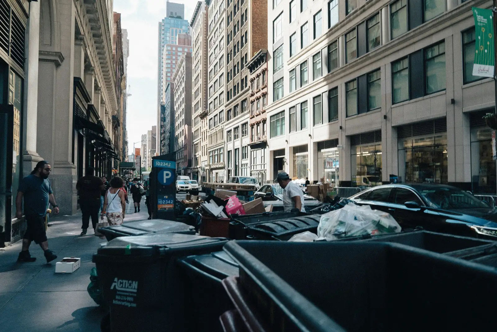 A city street lined with wheelie bins on collection day