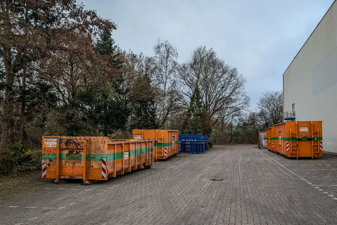 Orange roll-off containers lined up in a depot yard