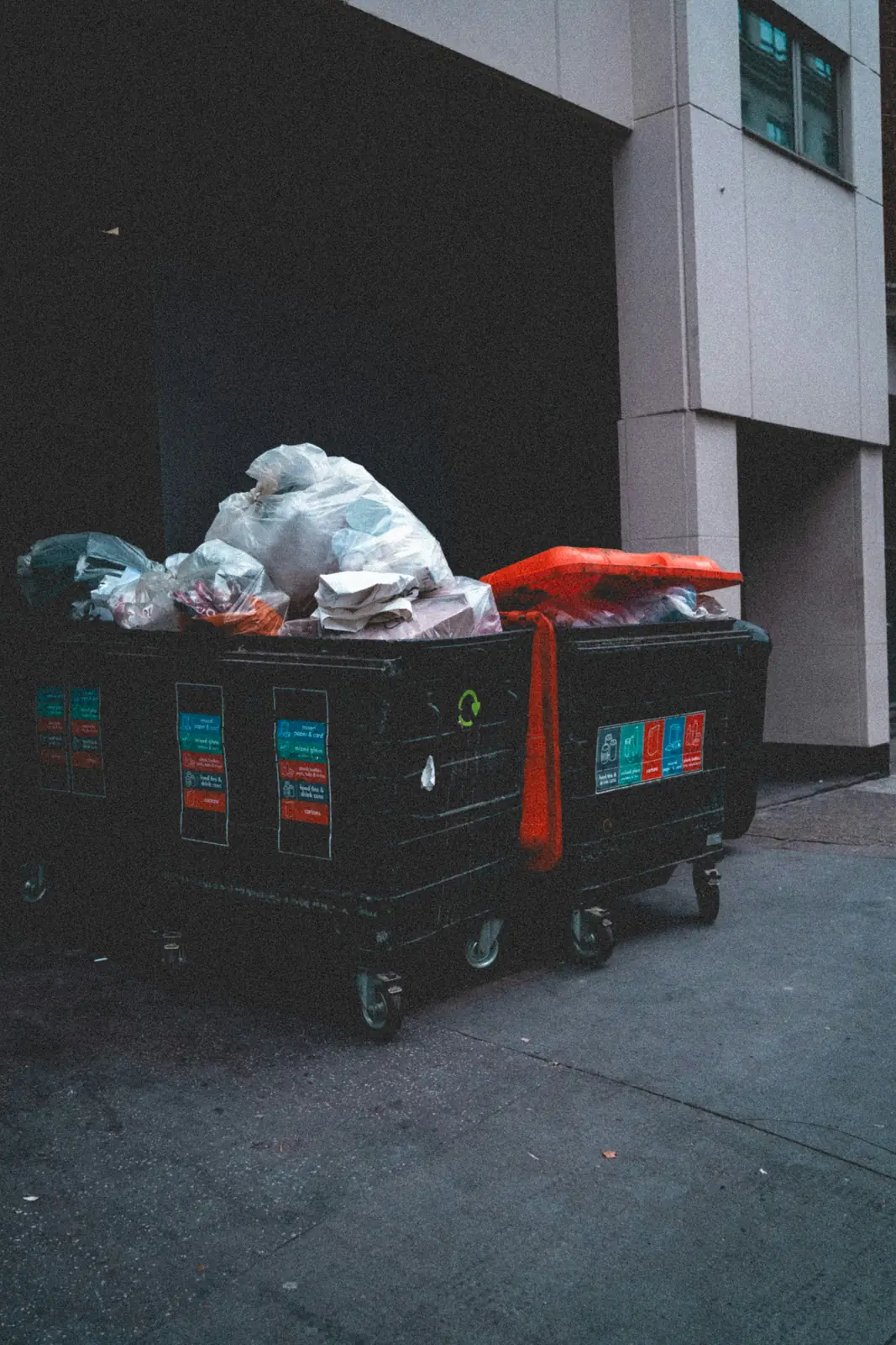Overflowing dumpsters in an alley at night