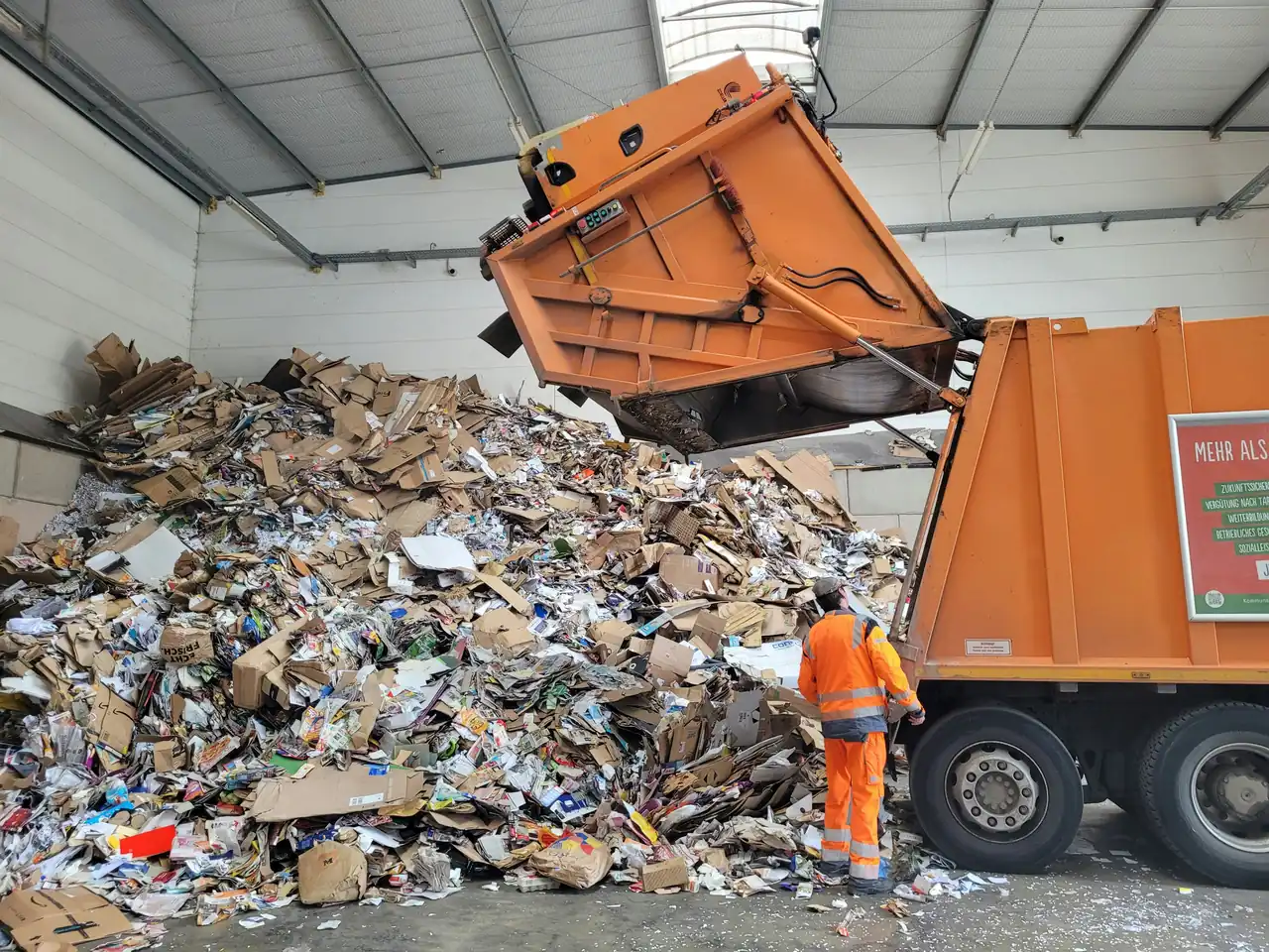 A refuse truck tipping cardboard at a transfer station