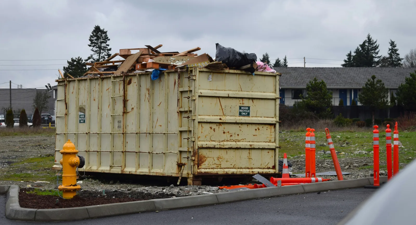 A roll-off container piled with timber for wood recycling