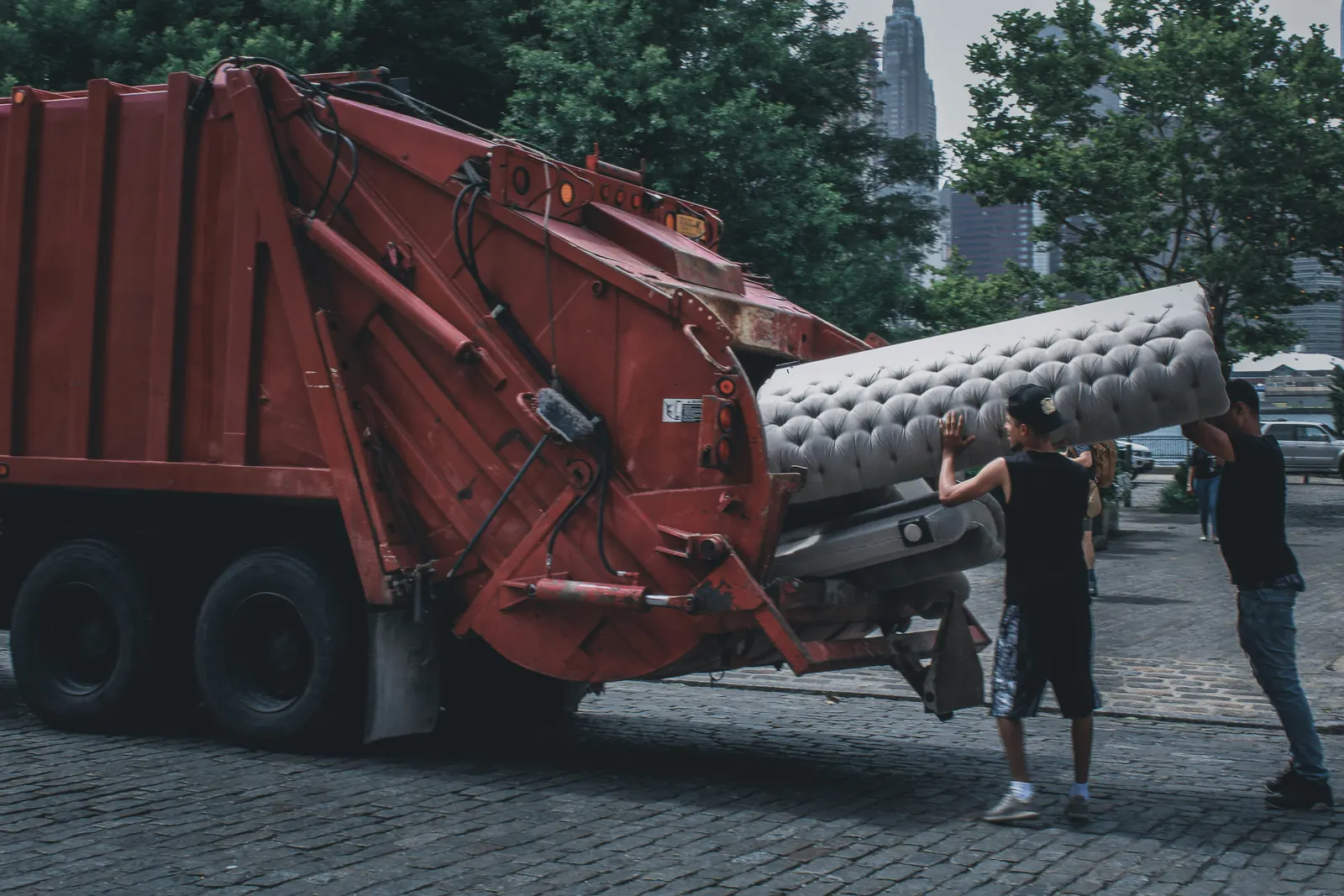 A sofa being loaded into a rear-load truck